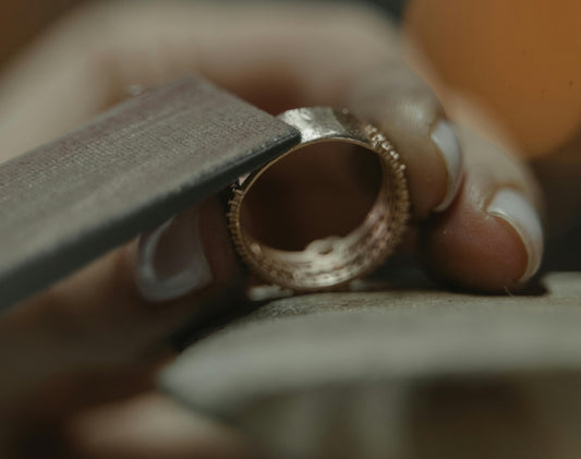 goldsmith women hands crafting a 14ct gold ring. polishing the ring